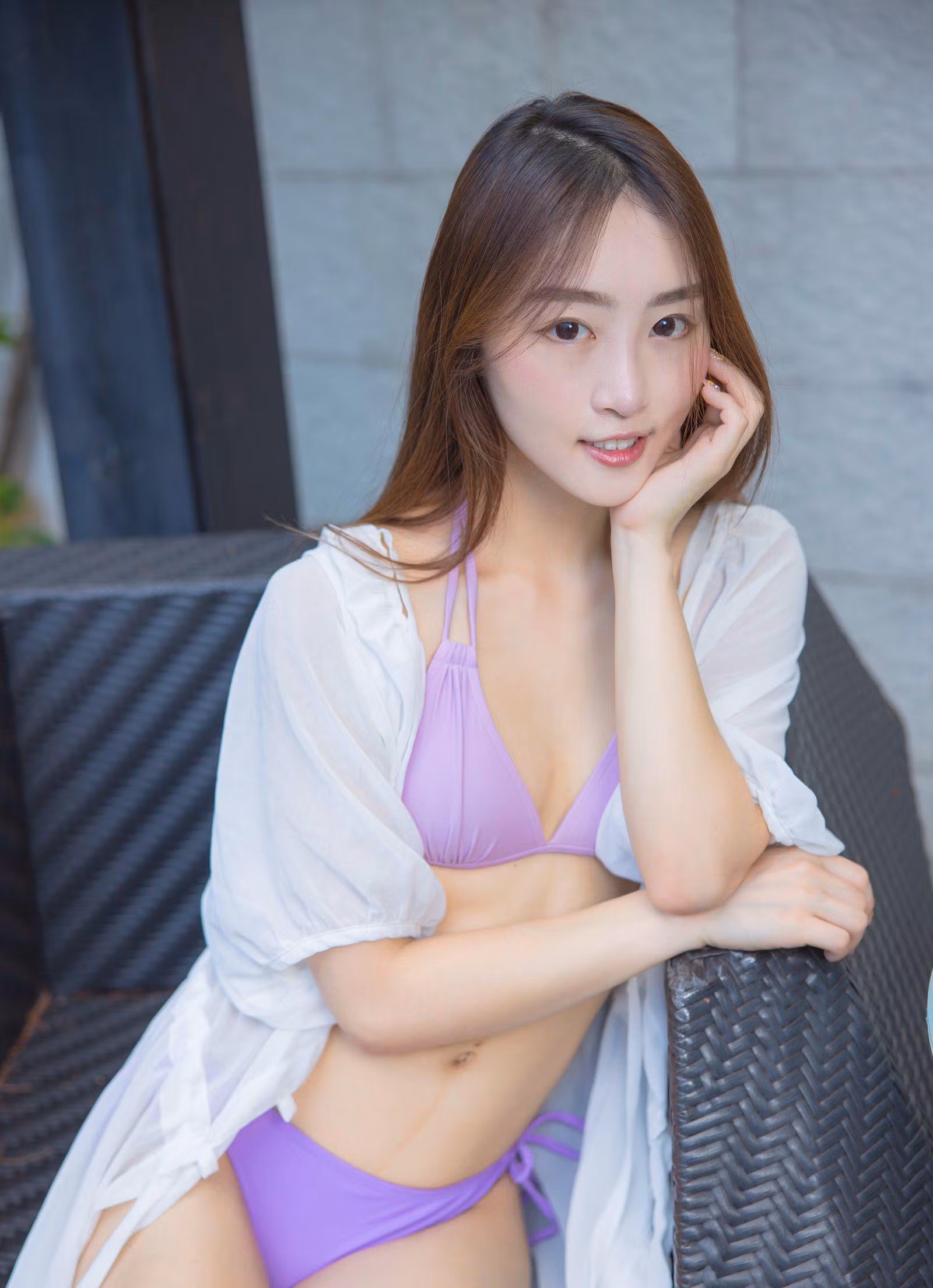 右侧模特身穿粉紫色泳衣披白纱姿态